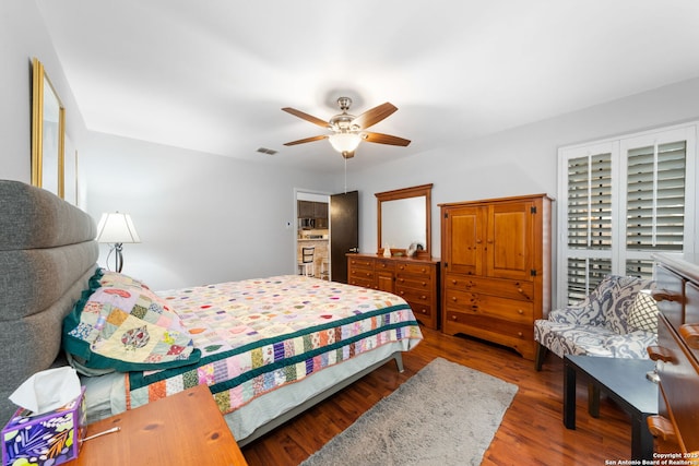 bedroom featuring a ceiling fan, visible vents, and wood finished floors