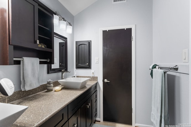 bathroom with lofted ceiling, visible vents, and vanity