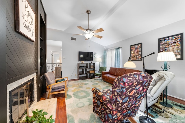 living area with lofted ceiling, a fireplace, wood finished floors, and visible vents