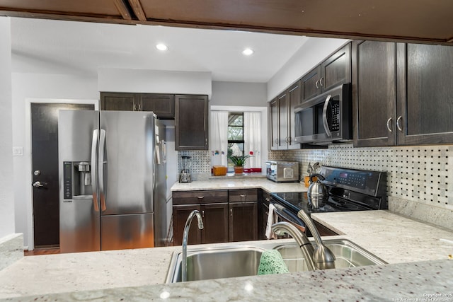 kitchen featuring dark brown cabinetry, a toaster, stainless steel appliances, a sink, and tasteful backsplash