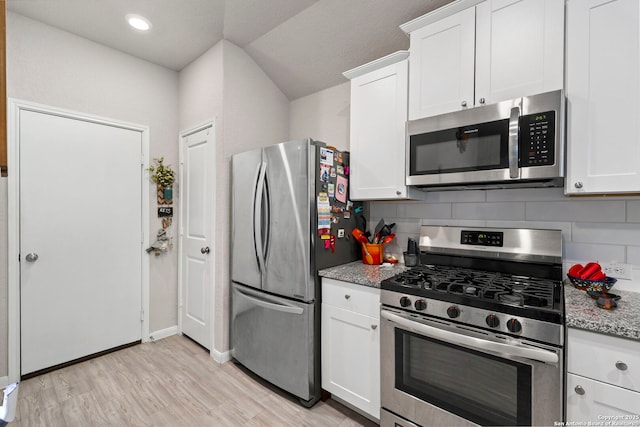 kitchen featuring stainless steel appliances, decorative backsplash, white cabinetry, and light stone countertops