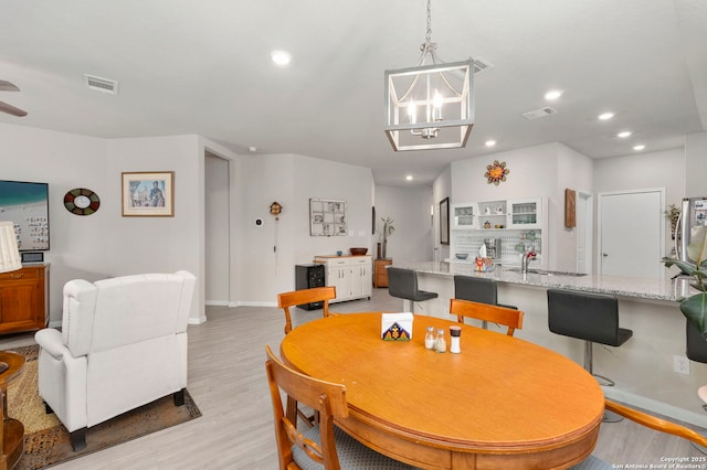 dining space with a notable chandelier, recessed lighting, visible vents, baseboards, and light wood-type flooring