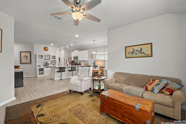 living area featuring visible vents, lofted ceiling, light wood-style flooring, ceiling fan, and recessed lighting