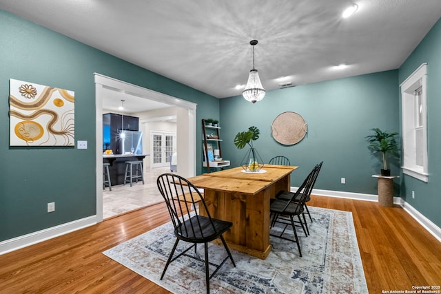 dining space with visible vents, baseboards, and wood finished floors