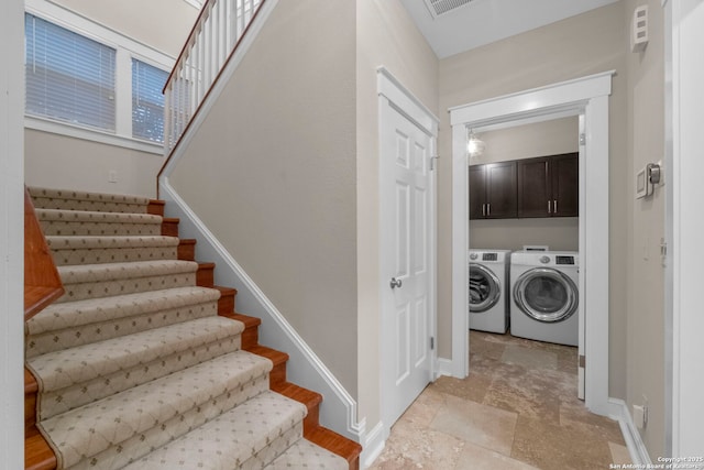 staircase with washing machine and dryer, stone finish flooring, and baseboards