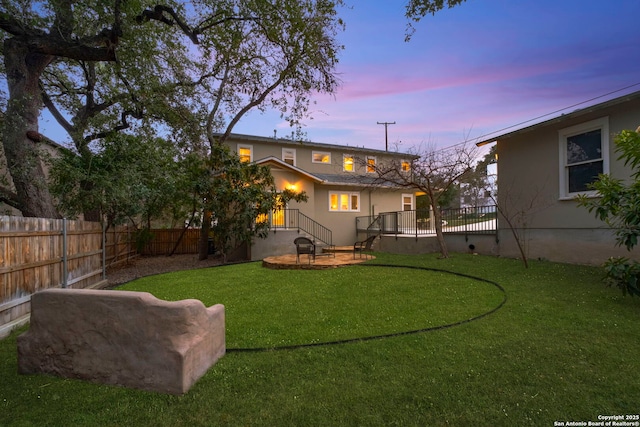 yard at dusk with a fenced backyard