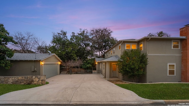 view of front of home featuring driveway, a chimney, fence, and stucco siding