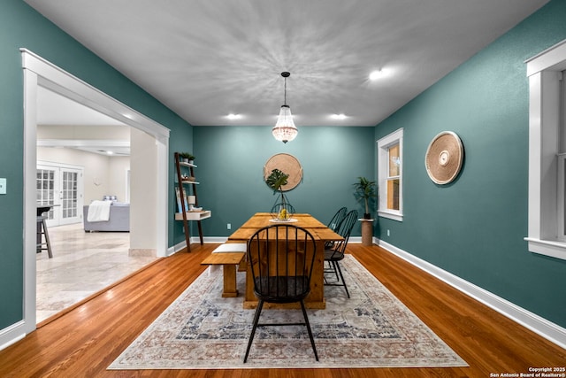 dining space featuring baseboards and wood finished floors