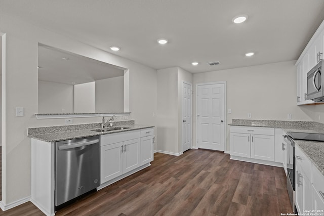 kitchen featuring appliances with stainless steel finishes, white cabinetry, and a sink