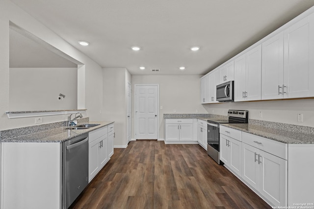 kitchen featuring stone countertops, visible vents, dark wood finished floors, appliances with stainless steel finishes, and white cabinetry