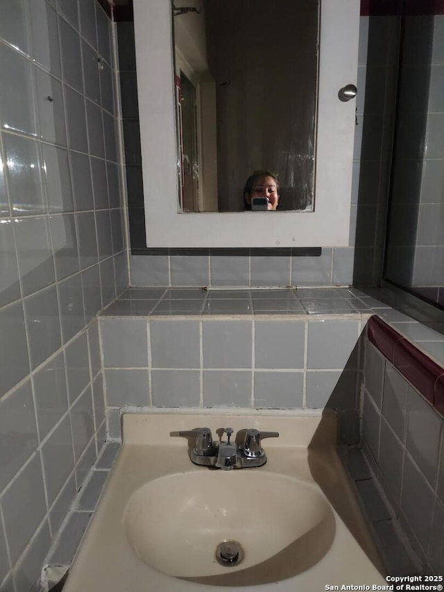 bathroom featuring a sink and decorative backsplash