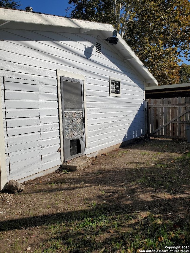 view of side of home featuring fence