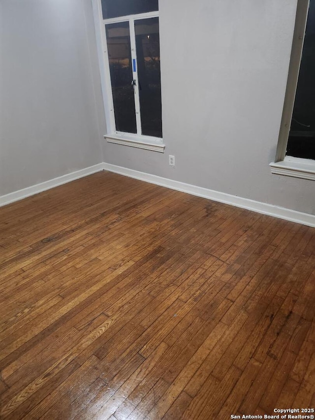 unfurnished room featuring baseboards and wood finished floors