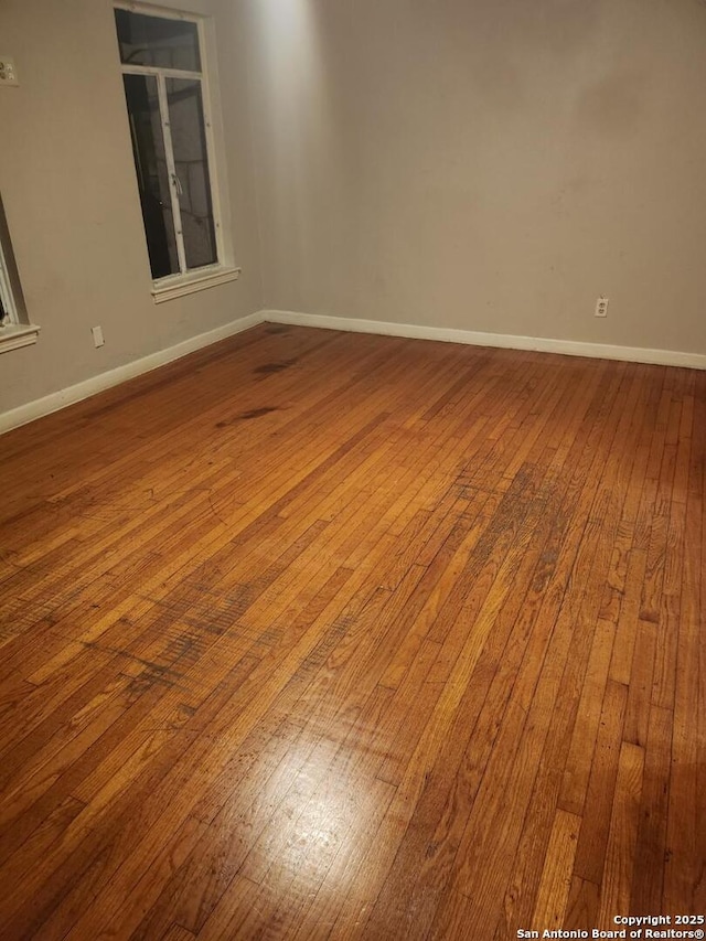 unfurnished room featuring wood finished floors and baseboards