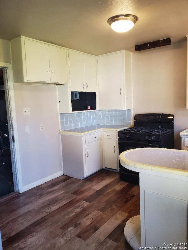 kitchen featuring black gas range, white cabinets, and tile countertops