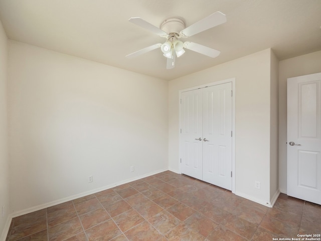 unfurnished bedroom with a ceiling fan, a closet, and baseboards