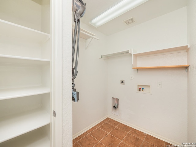 laundry room with gas dryer hookup, dark tile patterned floors, washer hookup, visible vents, and electric dryer hookup