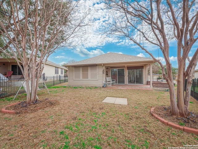 back of house featuring a shingled roof, a lawn, and fence private yard