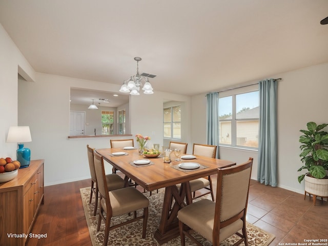 dining space featuring an inviting chandelier, visible vents, dark wood-style floors, and baseboards