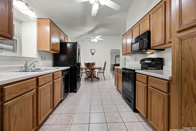 kitchen with brown cabinets, light countertops, a sink, and black appliances