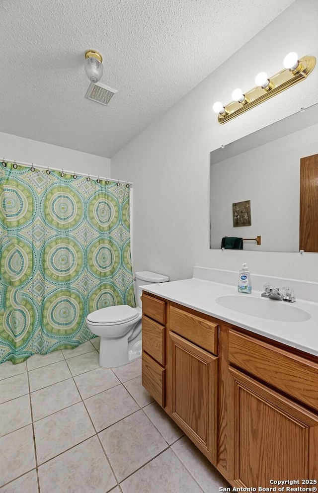 bathroom with a textured ceiling, tile patterned flooring, toilet, vanity, and visible vents