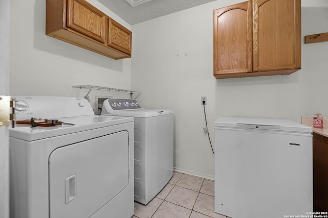 laundry area featuring washer and dryer, cabinet space, and light tile patterned flooring