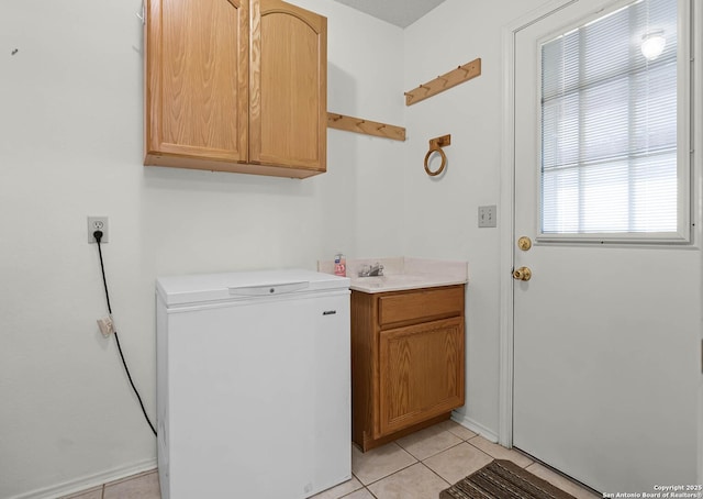 clothes washing area with light tile patterned floors