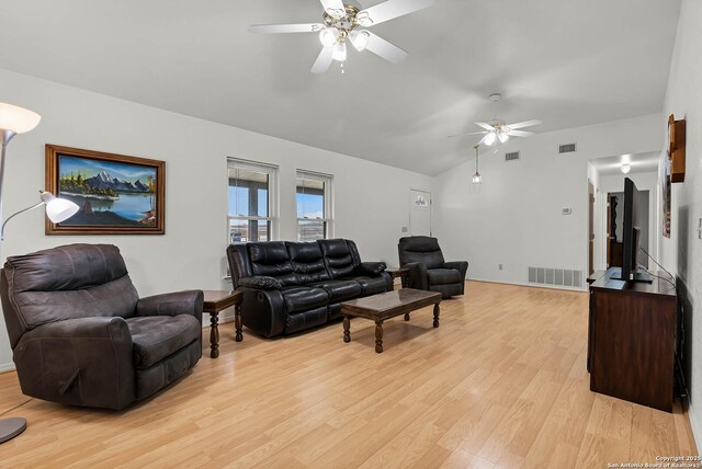 living area featuring light wood-style floors, visible vents, and vaulted ceiling