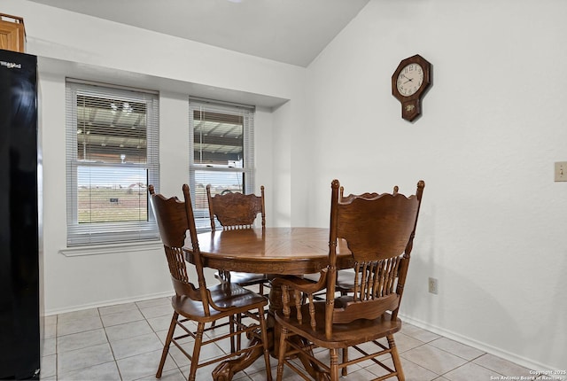 dining room featuring light tile patterned floors, vaulted ceiling, and baseboards