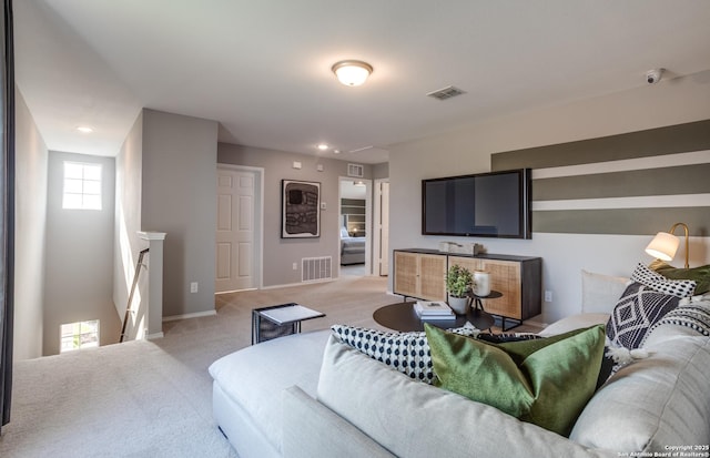 living area featuring light colored carpet, visible vents, and baseboards