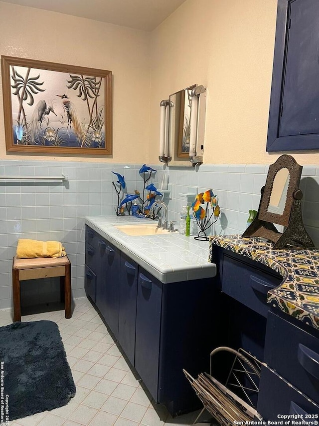 bathroom featuring a wainscoted wall, vanity, tile patterned flooring, and tile walls