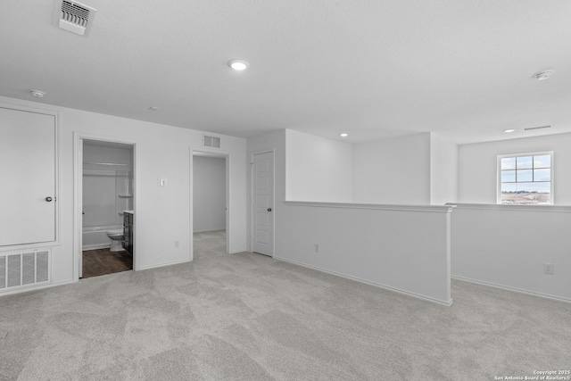 interior space featuring recessed lighting, visible vents, and light colored carpet