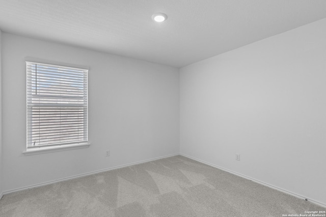 unfurnished room with light carpet, a wealth of natural light, and baseboards