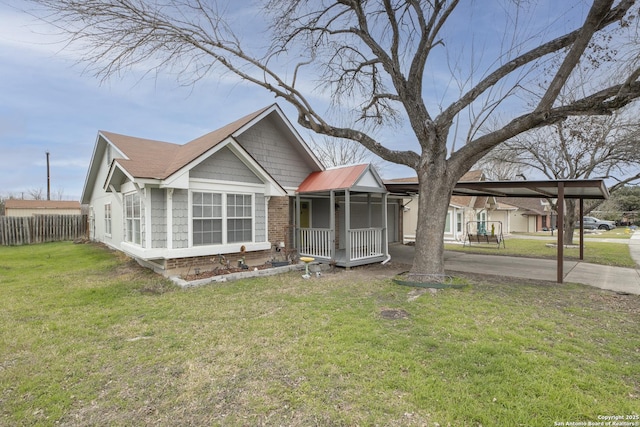 view of front of property with covered porch, brick siding, a front yard, and fence