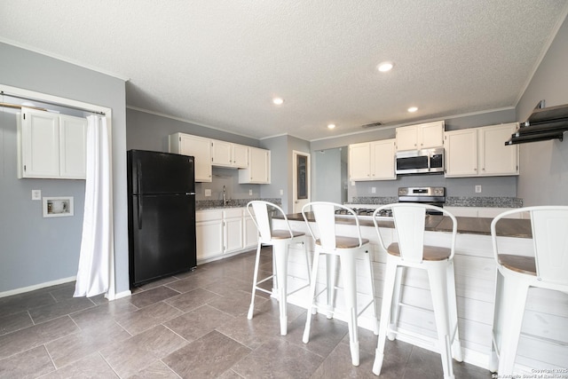 kitchen with appliances with stainless steel finishes, a kitchen island, white cabinetry, and a kitchen breakfast bar