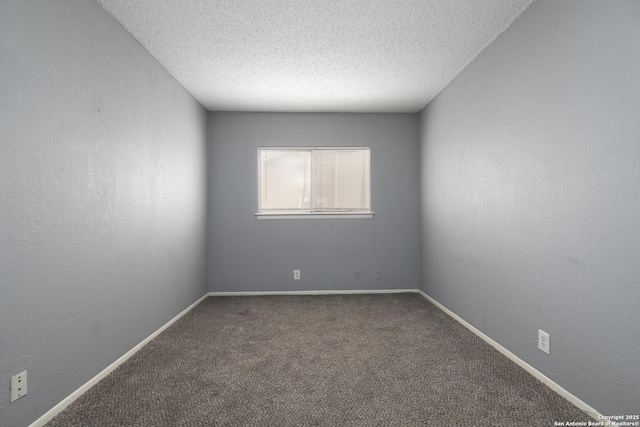 spare room featuring carpet floors, baseboards, a textured ceiling, and a textured wall