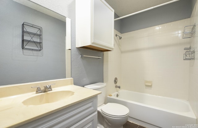 full bath with toilet, a textured wall, tub / shower combination, and vanity