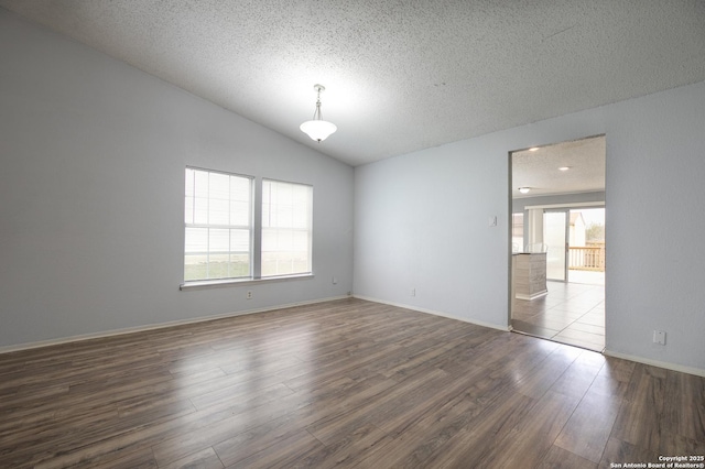 unfurnished room with lofted ceiling, dark wood-type flooring, a textured ceiling, and baseboards