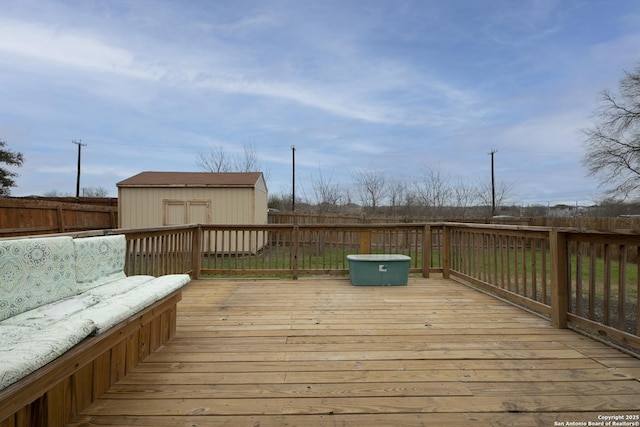 wooden deck featuring a storage shed, fence, and an outdoor structure