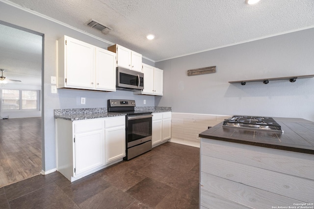 kitchen with visible vents, white cabinets, dark countertops, stainless steel appliances, and open shelves