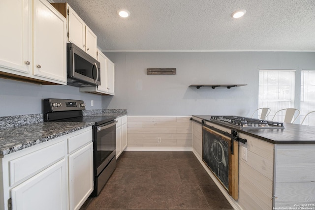 kitchen with open shelves, dark countertops, appliances with stainless steel finishes, wainscoting, and white cabinets