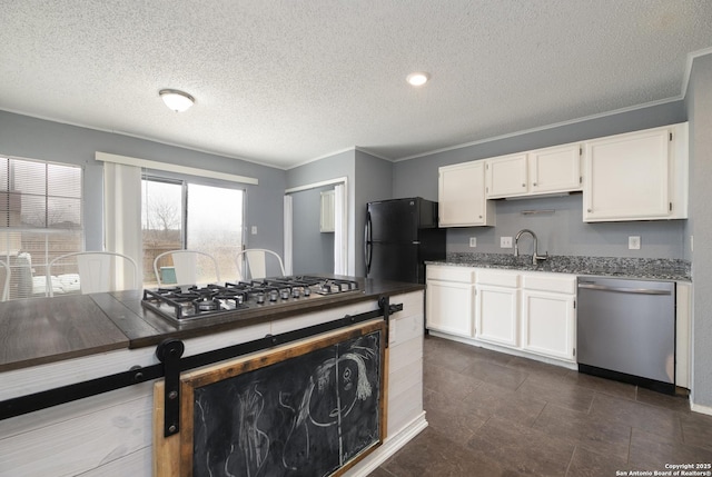 kitchen featuring white cabinetry, appliances with stainless steel finishes, and crown molding