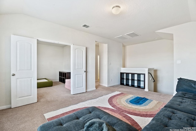 bedroom with visible vents, carpet floors, and vaulted ceiling