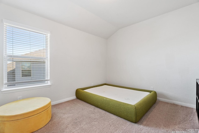 bedroom with vaulted ceiling, baseboards, and carpet floors