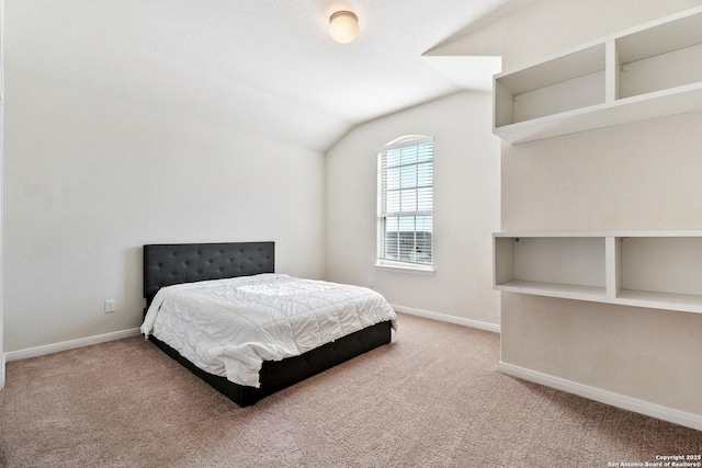 bedroom featuring baseboards, lofted ceiling, and carpet floors