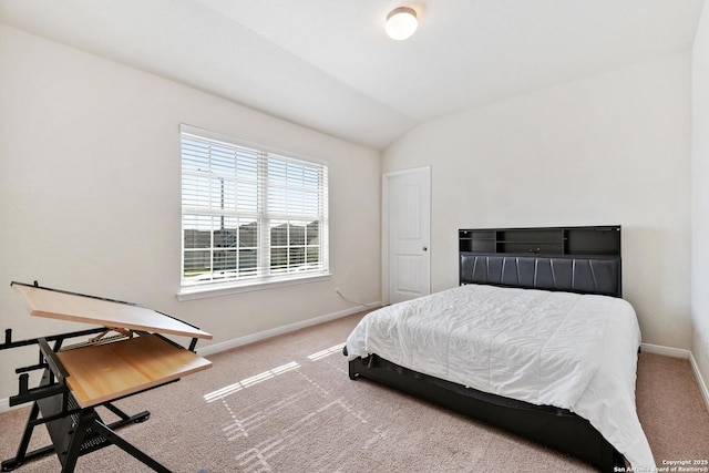 bedroom with vaulted ceiling, baseboards, and carpet floors