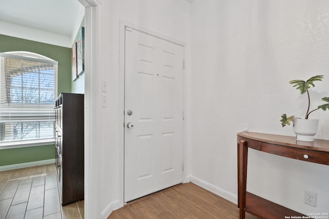 entryway with baseboards and light wood-style floors