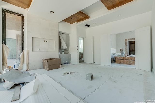 interior space with wood ceiling, a high ceiling, and visible vents