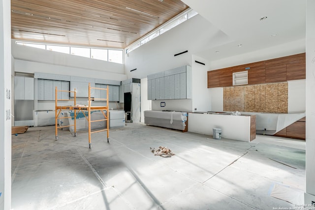 miscellaneous room with concrete floors and a high ceiling