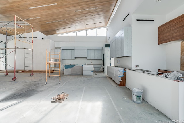 kitchen with a high ceiling, concrete floors, and wood ceiling